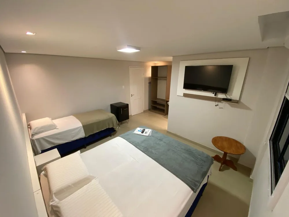 Suíte Luxo com cama de casal, enxoval branco e ar-condicionado